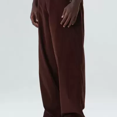 Calças castanho escuro largas em modelo com sapatos pretos