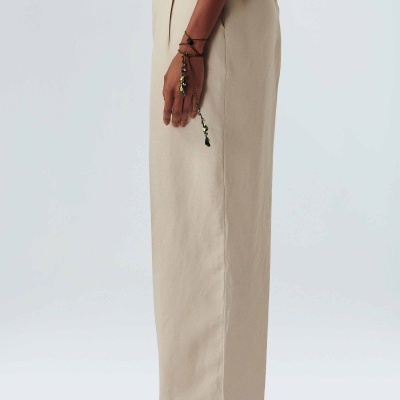 Calças bege de tecido com corte reto e cintura alta vistas de perfil