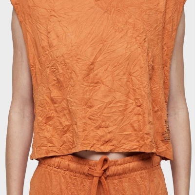 Top laranja sem mangas com textura amarrotada e calças a condizer