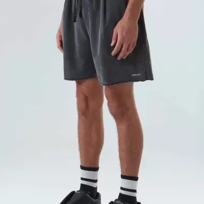 Calções cinza escuro masculinos com cós elástico e cordão, usados por homem com meias brancas e pretas e sapatos pretos.