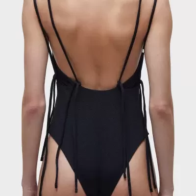 Fato de banho preto texturizado com tiras finas em fundo branco