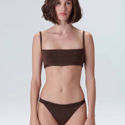 Modelo com biquíni castanho canelado em fundo branco