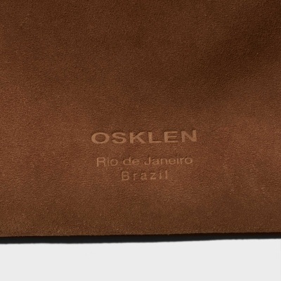 Material castanho em pele com texto embossado OSKLEN Rio de Janeiro Brazil