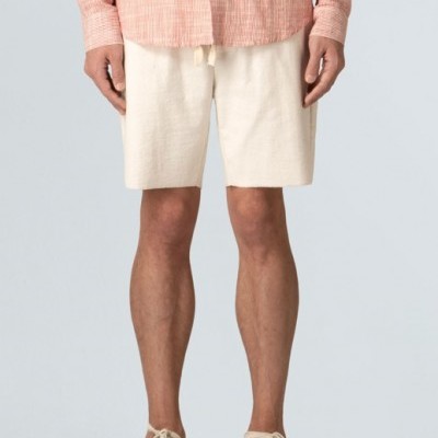 Calções masculinos claros com camisa rosa e sapatilhas bege