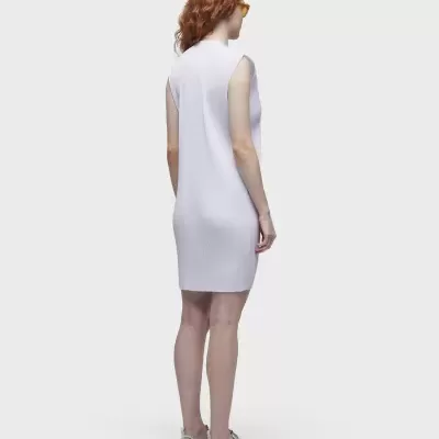 Vestido branco sem mangas numa modelo vista de costas com sapatos brancos e óculos amarelos