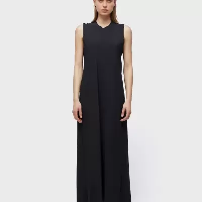 Vestido comprido preto sem mangas numa modelo com fundo claro.