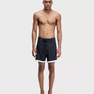 Homem a usar calções de banho pretos com cinto ajustável e bainha branca