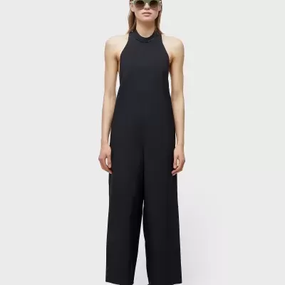 Macaquinho preto sem mangas e gola alta com calça larga em fundo cinza claro