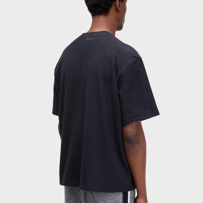 Pessoa de costas com t-shirt preta e calças cinzentas com listas pretas e brancas