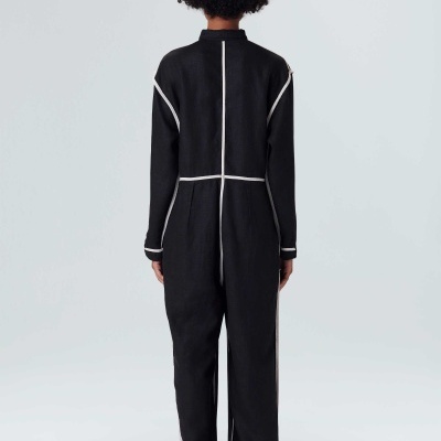 Macaquinho preto com riscas brancas, visto de costas, em fundo branco