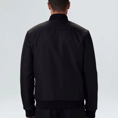 Casaco preto de tecido liso com gola alta visto pelas costas