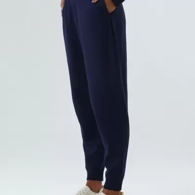 Calças de malha azul escuro com bolso lateral e ténis brancos