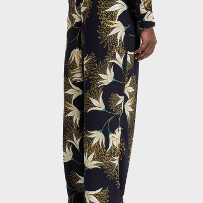 Calças com padrão floral em fundo preto usadas com sapatos castanhos