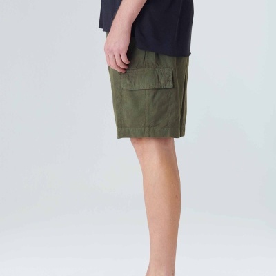 Calções cargo verdes com bolsos laterais usados com camiseta preta e mocassins bege