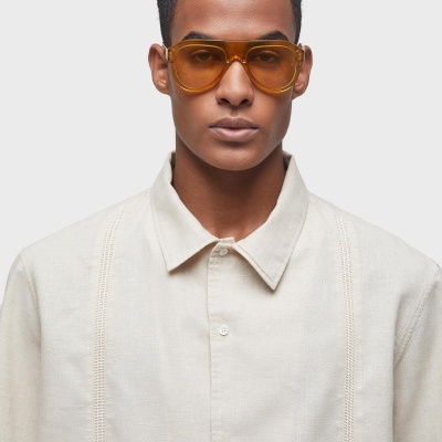 Óculos de sol amarelos com armação transparente e camisa bege de algodão