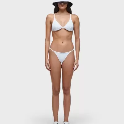 Mulher veste biquíni branco, chapéu branco e sandálias brancas