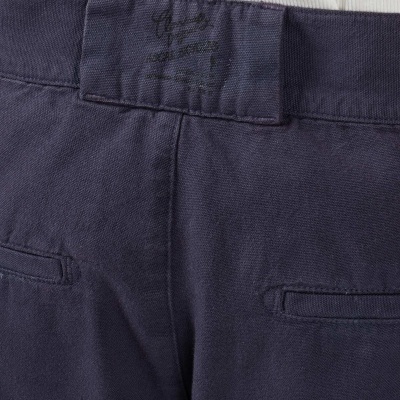 Calças de tecido azul escuro com bolsos falsos e etiqueta preta na cintura