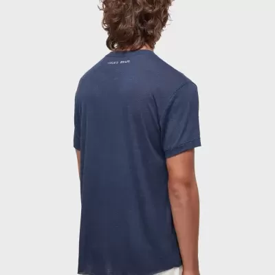 T-shirt azul escura de manga curta vista de costas com texto branco pequeno perto da gola