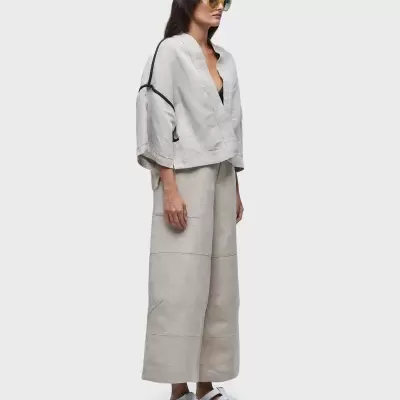 Mulher com roupa cinza claro e óculos de sol amarelos