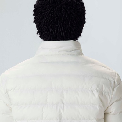Casaco acolchoado branco e touca negra vista de trás