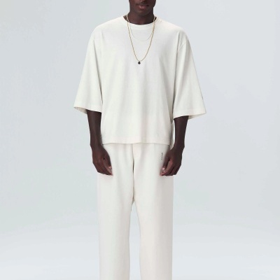 Homem com conjunto branco largo e ténis brancos