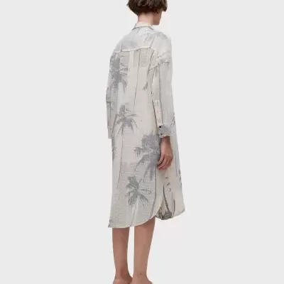 Vestido camisa comprido bege com padrão de palmeiras cinza visto de costas