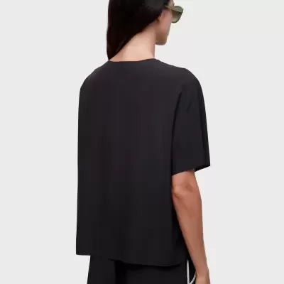 Pessoa de costas com t-shirt preta e óculos verdes