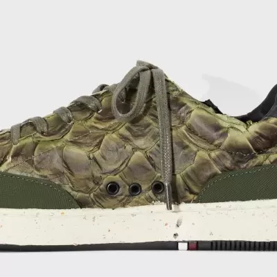 Tênis verde com padrão de escamas e sola branca