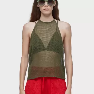 Mulher com top de malha verde e calções vermelhos com óculos de sol verdes