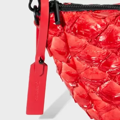 Bolsa vermelha texturizada com fecho preto e etiqueta OSKLEN