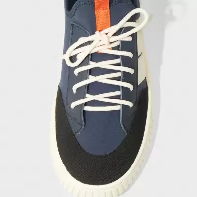Tênis desportivo azul com detalhes preto e branco e atacadores brancos