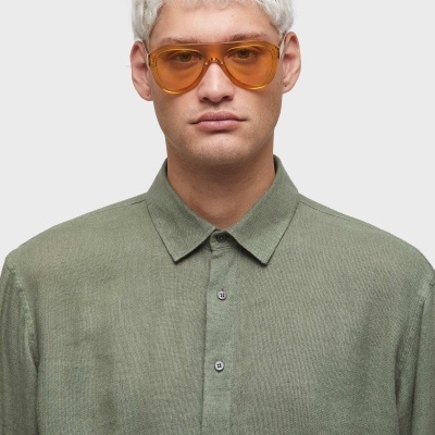 homem com camisa verde e óculos de sol amarelos