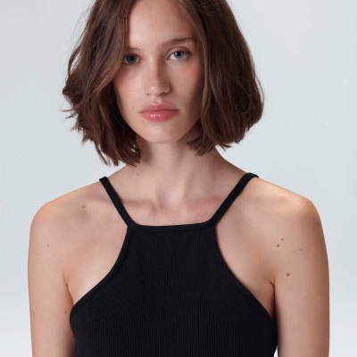 Mulher com camisola preta de alças finas e textura canelada