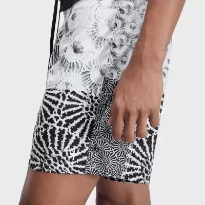 Calções de banho pretos e brancos com padrão abstrato e cordão na cintura, usado por modelo