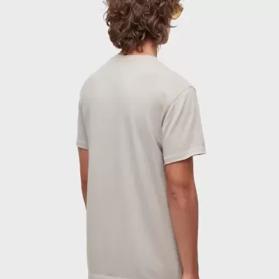 T-shirt cinza claro de manga curta vista de costas e calças brancas com bolso grande