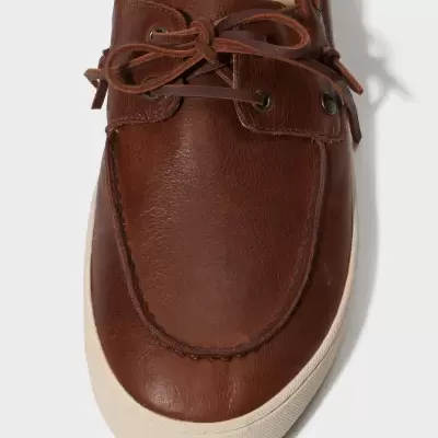 Sapatilha castanha tipo mocassim com sola branca e atacadores de pele