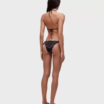 Mulher de costas vestindo biquíni preto com padrão quadriculado branco e rosa