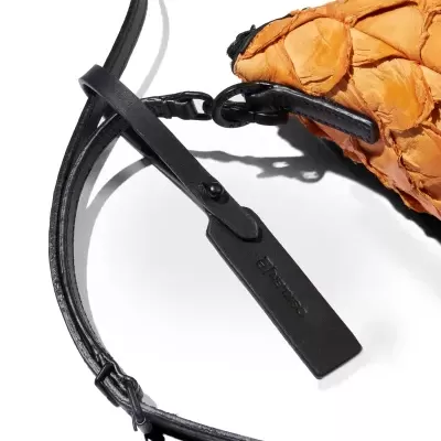 Bolsa de couro laranja texturizada com alça preta e etiqueta Malabar