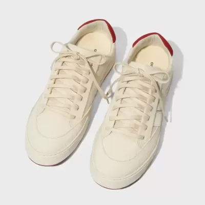 Par de sapatilhas brancas com detalhe vermelho na parte de trás