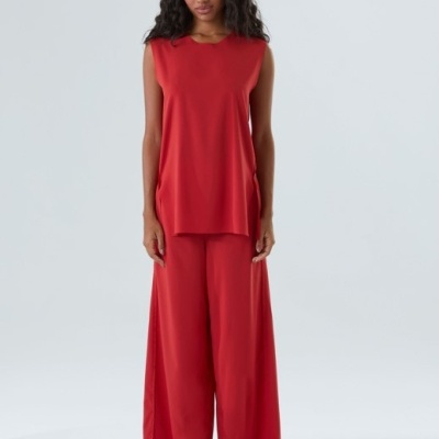 Conjunto feminino vermelho com top e calças largas, sandálias brancas e pretas