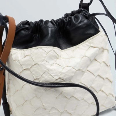 Mala saco preta e branca com padrão geométrico em relevo