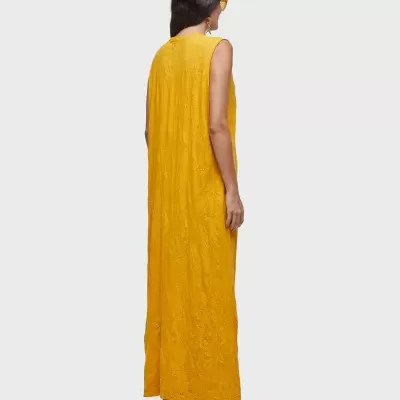 Vestido comprido amarelo mostarda com padrão floral, visto de costas