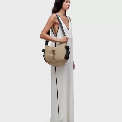Modelo com vestido branco e mala tiracolo bege com pormenores pretos