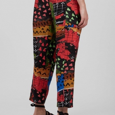 Calças coloridas com padrão geométrico e sandálias pretas vista de trás