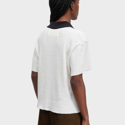 Pessoa de costas com camisola branca de manga curta e gola preta.