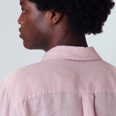 Camisa rosa de linho vista de costas num fundo cinzento