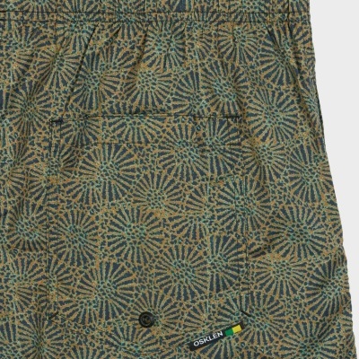 Calções com padrão gráfico azul e castanho, bolso traseiro direito com botão e etiqueta OSKLEN.