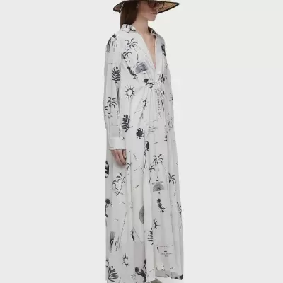 Vestido comprido branco com padrão preto, chapéu de palha, óculos e sapatos brancos