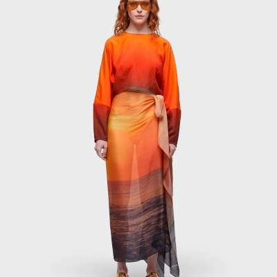 Vestido comprido laranja com amarração na cintura, sandálias douradas e óculos de sol laranja