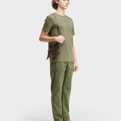 Homem com roupa e acessórios na cor verde e castanho